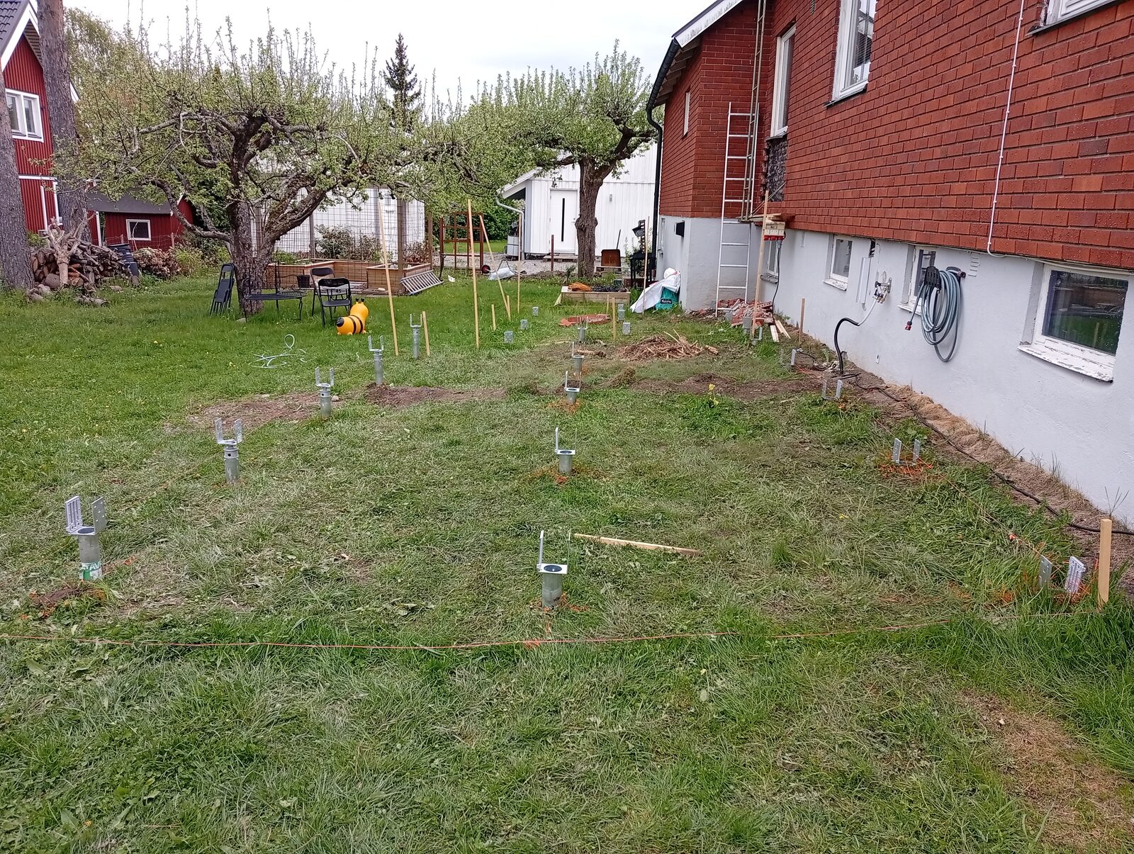 Markskruvar för altan på villatomt före montering av bärlina och trall